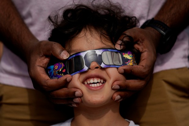 Viewers use special glasses to watch from San Antonio, as the moon moves in front of the sun during an annular solar eclipse, or ring of fire, Saturday, Oct. 14, 2023. (AP Photo/Eric Gay)