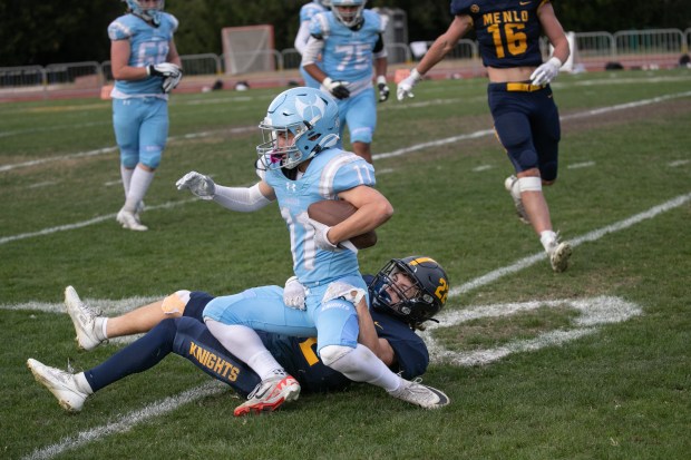 Hillsdale's Drew Rollolazo (11) is brought down by Menlo School's Jack Enright (22) on a pass play in the second quarter at Menlo School on Friday, Oct. 13, 2023, in Atherton, Calif. (Photo by Jim Gensheimer)