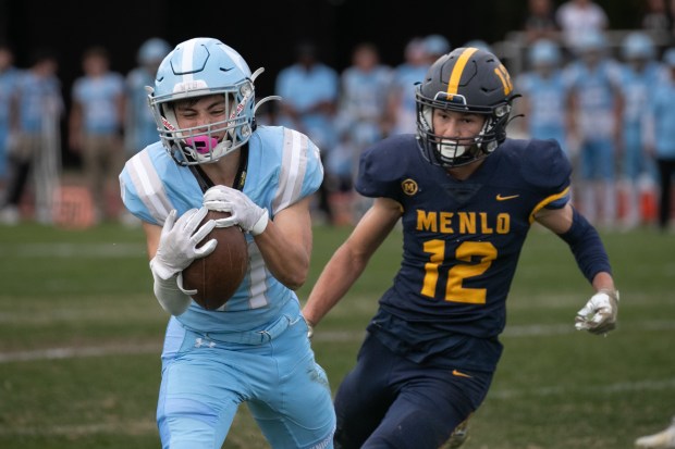 Hillsdale's Drew Rollolazo (11) catches a pass against Menlo School's Tyler Fernandez (12) in the fourth quarter at Menlo School on Friday, Oct. 13, 2023, in Atherton, Calif. The play set up a touchdown for his team. (Photo by Jim Gensheimer)
