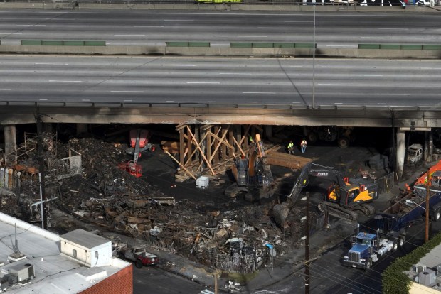 The site of a fire is shown under Interstate 10, in an aerial view, Monday, Nov. 13, 2023, in Los Angeles. Los Angeles drivers are being tested in their first commute since a weekend fire that closed a major elevated interstate near downtown. (AP Photo/Jae C. Hong)