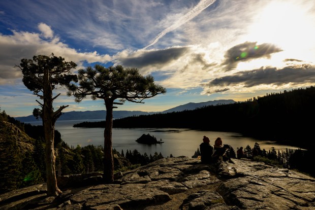 Visitors watch an annular solar eclipse briefly shine hrough layers of clouds from Emerald Bay in Lake Tahoe, Calif., on Saturday, Oct. 14, 2023. (Ray Chavez/Bay Area News Group)