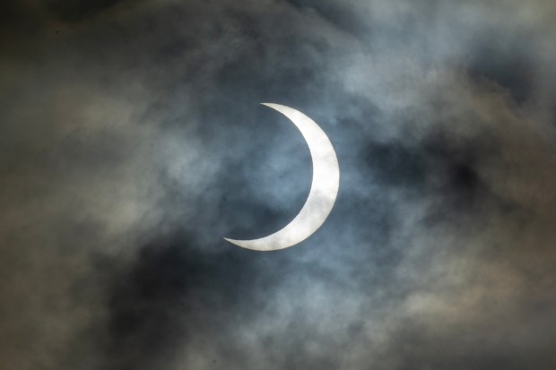 The annular eclipse becomes viewable briefly through the clouds during a viewing event, Saturday, Oct. 14, 2023, on the intramural fields at Stanford University. (Karl Mondon/Bay Area News Group)