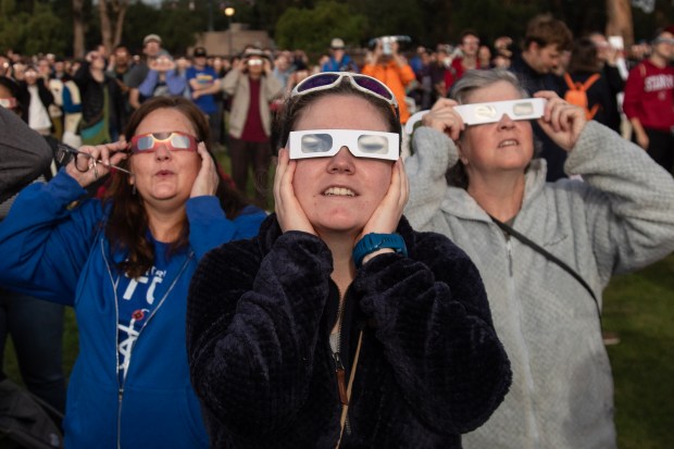 Spectators use special glasses to enjoy the annular eclipse as it becomes visible during a viewing event, Saturday, Oct. 14, 2023, on the intramural fields at Stanford University. (Karl Mondon/Bay Area News Group)