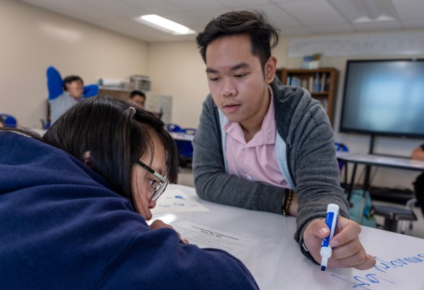 John Carlo Chan, a special education teacher from the Philippines, instructs Rachel Lee at Oceano High School in Pacifica, Calif., Wednesday, Nov. 1, 2023. Chan is among the growing number of international teachers helping California fill its teacher shortage. (Karl Mondon/Bay Area News Group)