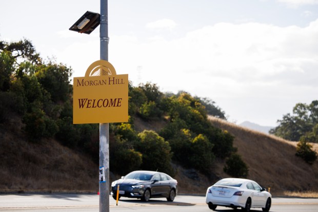Cars drive by a license plate reader mounted above a greeting sign on Santa Teresa Boulevard in Morgan Hill, California, on Oct.10, 2023. (Dai Sugano/Bay Area News Group)