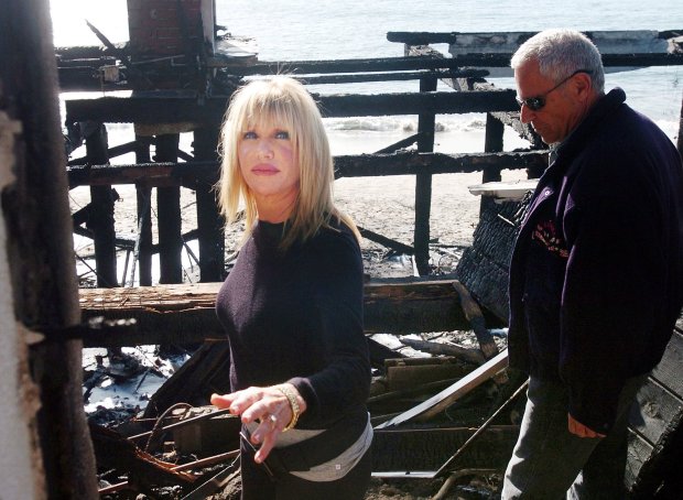 Actress Suzanne Somers, left, and her husband, Alan Hamel, walk through the ruins of their former home on Malibu Road on Tuesday morning, Jan. 9, 2007. Somers' home was one of four destroyed by a wind-driven wildfire that swept through an exclusive seaside neighborhood of multimillion-dollar homes, a spokesman confirmed Tuesday. (AP Photo/Los Angeles Daily News, Tina Burch)